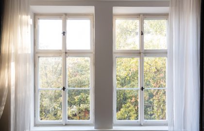 Fall, autumn season. Trees with yellow leaves out of two closed white wooden windows